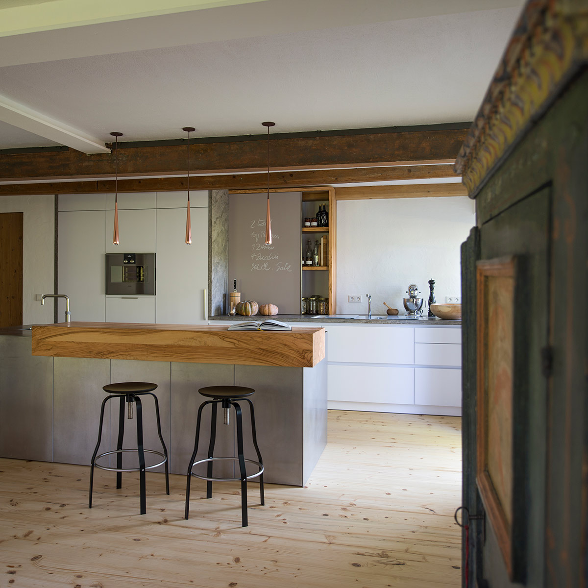 Küche in altem Bauernhaus mit Kochinsel aus Edelstahl und Theke aus Olivenholz.