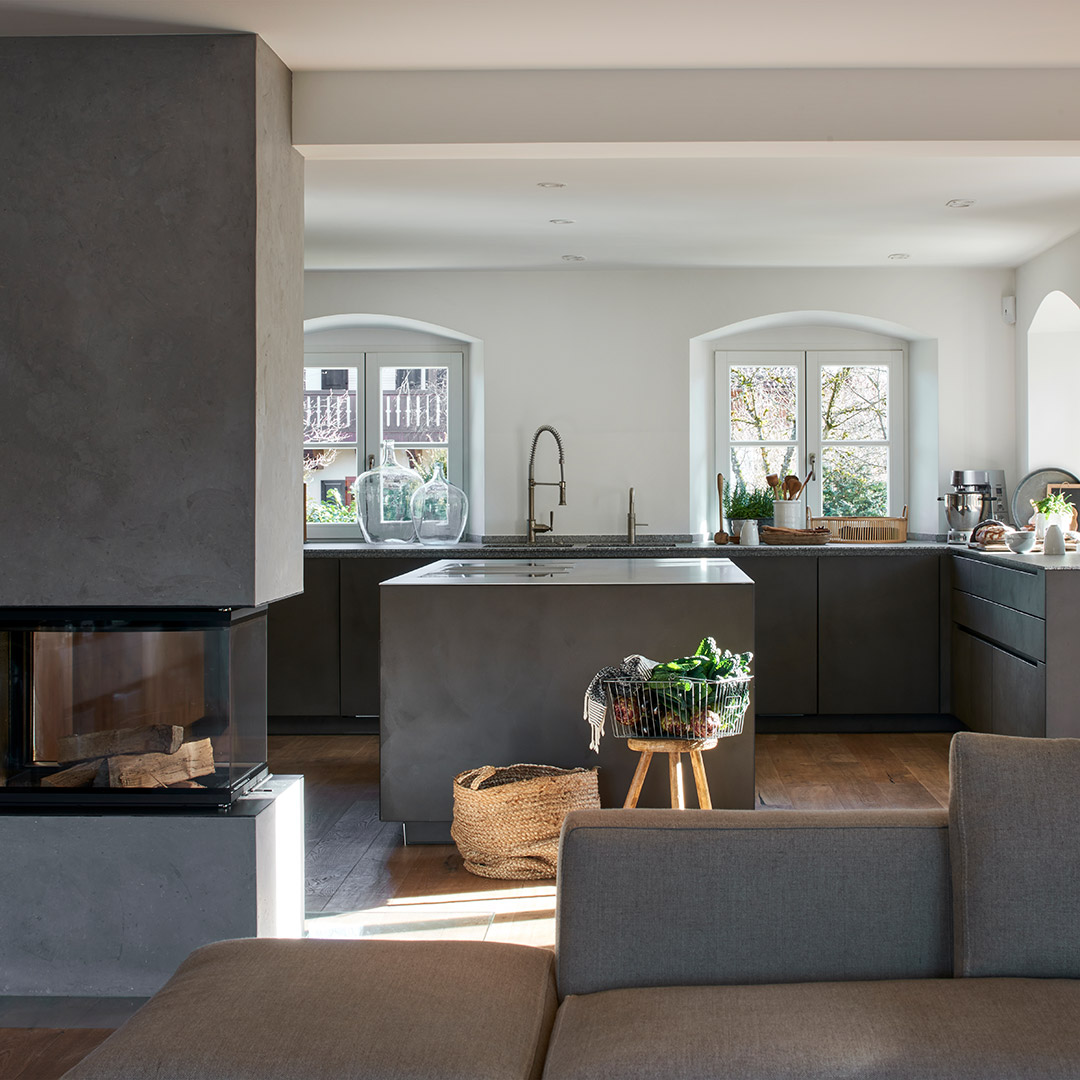 Küche mit Rückwand aus Eiche, Betonfronten und großer Back-Kitchen mit Essbereich.